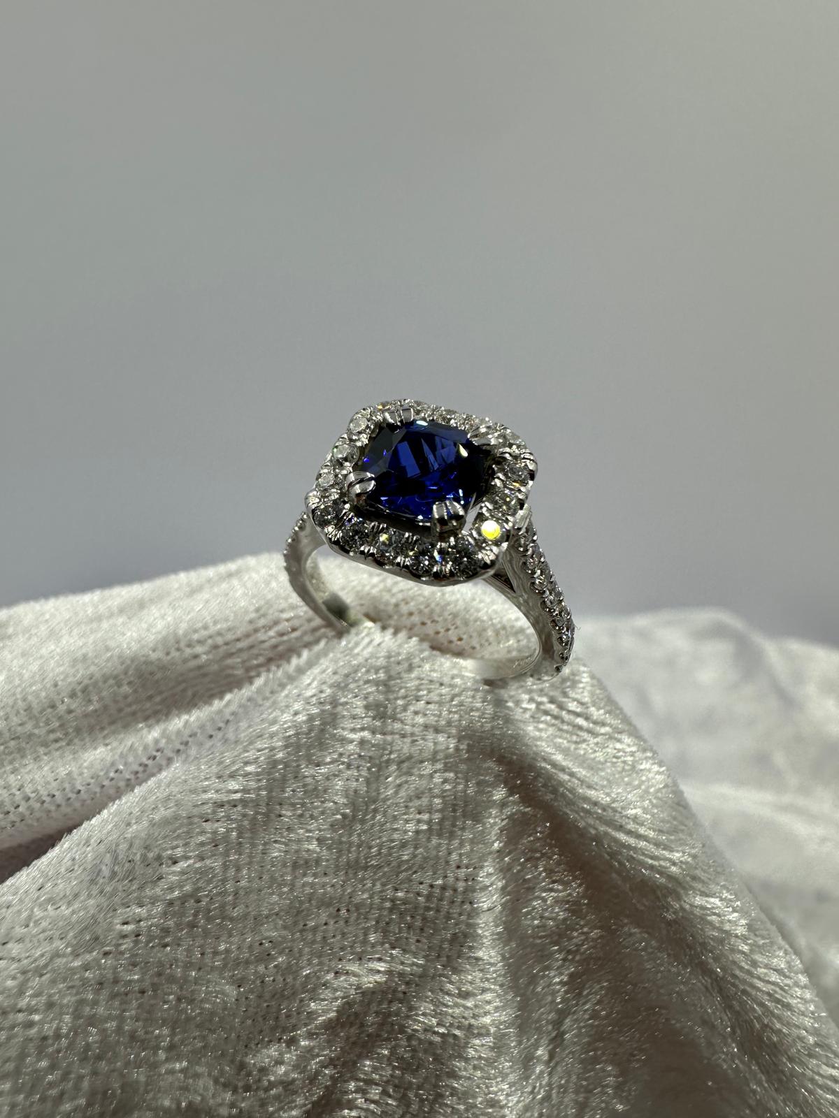 Deep blue cushion sapphire in halo diamond ring