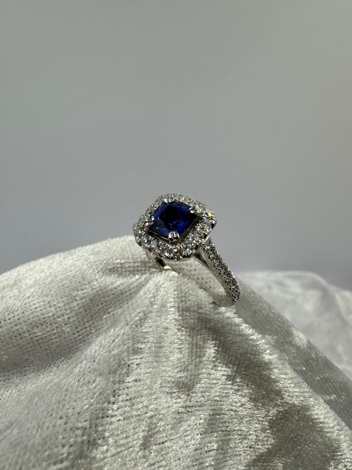 Deep blue cushion sapphire in halo diamond ring