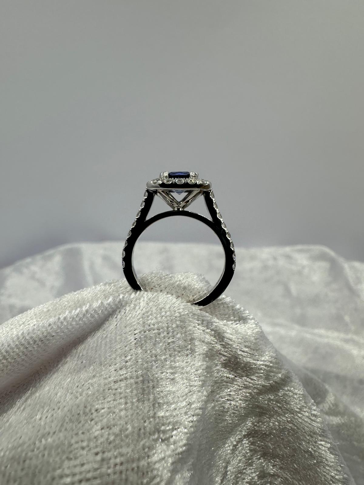 Deep blue cushion sapphire in halo diamond ring