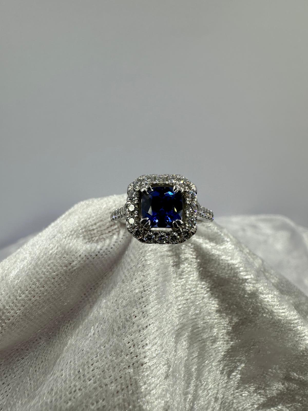 Deep blue cushion sapphire in halo diamond ring