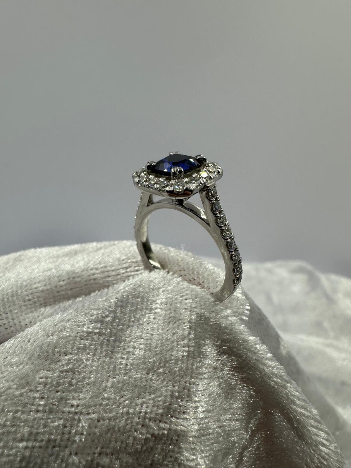 Deep blue cushion sapphire in halo diamond ring