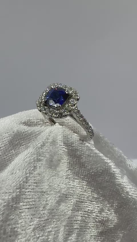 Deep blue cushion sapphire in halo diamond ring